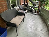 Front view showing two-seater sofa with beige cushion and wicker frame