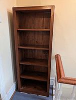 Front view of solid oak bookshelf with five shelves, showing natural wood grain and sturdy construction.