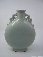 Front and side view showing celadon glaze and shape of vase along with subtle incised dragon detail.