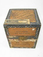 View of vintage wooden cigar box with front paper label 'Tucketts Marguerite' and 'Blended in Havana'. Shows wear and paper damage.