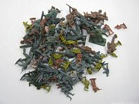 Photo showing a generically styled assortment of plastic toy soldiers in multiple colors such as green, brown, and gray, spread in a pile on a flat surface. Several soldiers are in action poses.