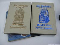 Four vintage slot machine books arranged side by side showing covers of two hardbound 'Slot Machines of Yesteryear' operator's companion volumes for Watling and Mills models.