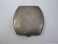 Top view showing engraved floral pattern and monogram on vintage sterling silver compact.
