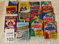 Photo showing all 14 unopened packs of sports cards from multiple brands and years arranged flat, clearly showing logos and pack details.
