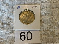 Close-up photo of 1943 Walking Liberty half dollar in white cardboard holder showing obverse side