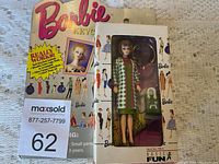 Original Barbie keychain doll in packaging with colorful vintage Barbie outfit illustrations in background