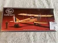 Photo of sealed model kit box showing Curtiss Jenny replica biplane artwork and branding.
