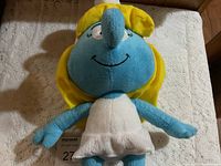 Full front view of Smurfette plush on white surface showing body, arms, legs and details.
