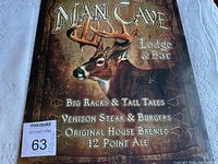 Close-up of the tin sign showing the design and text with a detailed view of the deer and lettering.