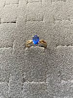Front view of 10K gold ring with dark blue oval stone, showing the stone color and setting