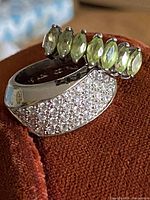 Photo showing two vintage sterling silver rings, one with green marquise-shaped stones and the other with clear round stones.