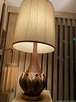 Full view of the vintage mid-century modern ceramic base table lamp with beige fabric shade.