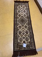 Full view of the rectangular vintage wool rug with fringes on the top and bottom edges, laid flat on floor.