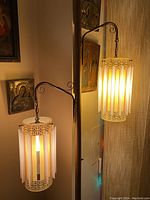 Full view of the vintage floor lamp with two hanging cylindrical lampshades emitting warm light.