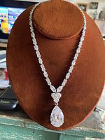 Full view of the necklace displayed on a brown velvet stand showing the entire length and pendant design