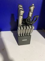 Front view of Farberware black knife block with knives and scissors inside.
