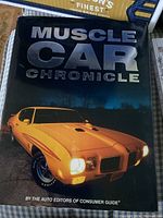 Front cover of Muscle Car Chronicle book featuring a yellow muscle car with headlights on.