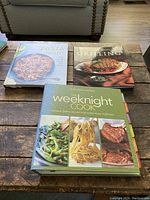 Photo of three William-Sonoma cookbooks laid out on a wooden surface: Pasta Night, Grilling, The Weeknight Cook.