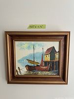 Front view of framed vintage ship painting with dimensions taped on wall above