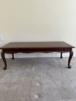Full view of vintage wooden coffee table showing its design and leg style.