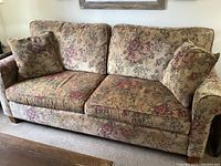 Full view of the Broyhill couch showing structure, cushions and two pillows in taupe floral tapestry upholstery