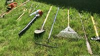 Wide view of all garden tools laid out on grass