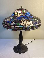 Full view of lamp showing stained-glass shade and metal base