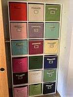 Full view of two stacked white cube shelving units with colorful fabric bins in all compartments