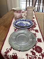 Wide shot showing all items arranged on embroidered linen table runner on wooden table