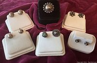 Photo showing four pairs of very old sterling screw back earrings, two single screw back earrings including one matching a ring, and one pair of post earrings.