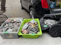 Photo showing three containers filled with assorted craft rocks in various sizes and colors, including painted and decorated pieces
