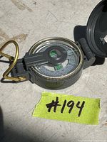 Top down view showing the compass face, directional markings and brass sighting wire.