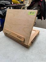 Full view of folded wooden desktop easel with Meeden branding and adjustment hinges.