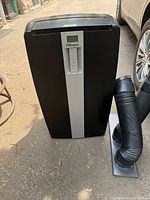 Front view of Danby Premiere portable air conditioner with vent hose beside it.