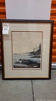 Framed art print showing the full coastal scene with trees, rocks, and waves.