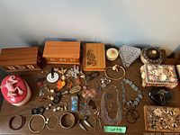 Overview of all jewellery boxes and assorted jewellery items laid out on table.