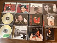 Lot of music discs including CDs and tape cassettes by Nat King Cole, Bing Crosby, Frank Sinatra, Paul Potts, Andrea Bocelli, Dean Martin, and Helmut Lotti