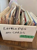 Box labeled 'Envelopes and Cards' filled with assorted greeting cards and envelopes.
