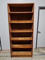 Front view of the 5-shelf wooden bookcase showing all shelves and the wood grain.