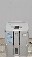 Full front and top view of used DeLonghi DD50P dehumidifier showing label for 50 pints per day capacity and built-in heavy duty pump.