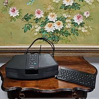 Bose Wave Radio and Kensington keyboard shown on wooden table with floral background, front view