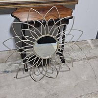 Front view of the metal flower frame wall mirror showing the petal design and central mirror.