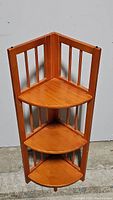 Front view of wooden corner folding bookshelf with three triangular shelves