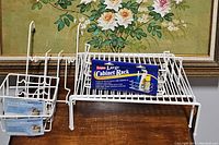 Two Grayline large cabinet shelf wire racks with white finish, one with packaging card showing brand.