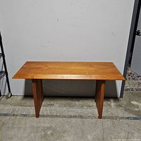 Front view of mid-century modern teak console/sofa table showing rectangular top and two wide supporting legs.