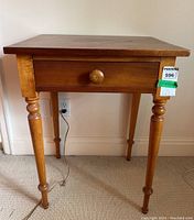 Front view of pine lamp table showing single drawer and turned legs