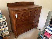 Three-quarter front view showing overall shape, bun feet, and raised backboard