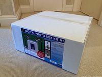 Sealed white shipping box with printed label ‘Digital Photo Box Kit #1’