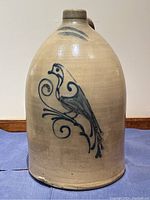 Full front view of stoneware jug on blue cloth