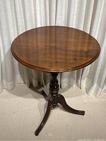 Front view of table showing circular top and tripod base